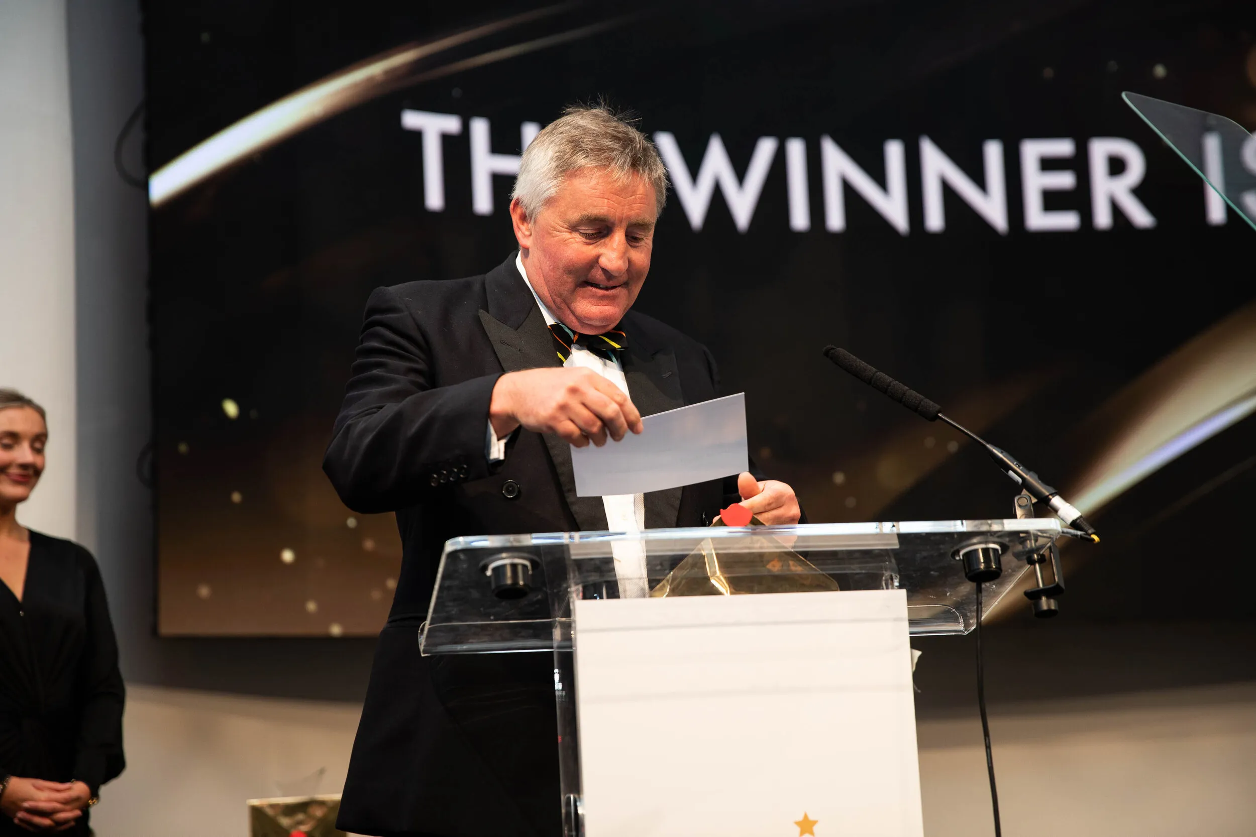 Awards ceremony announcing winner at lectern, London corporate event photography