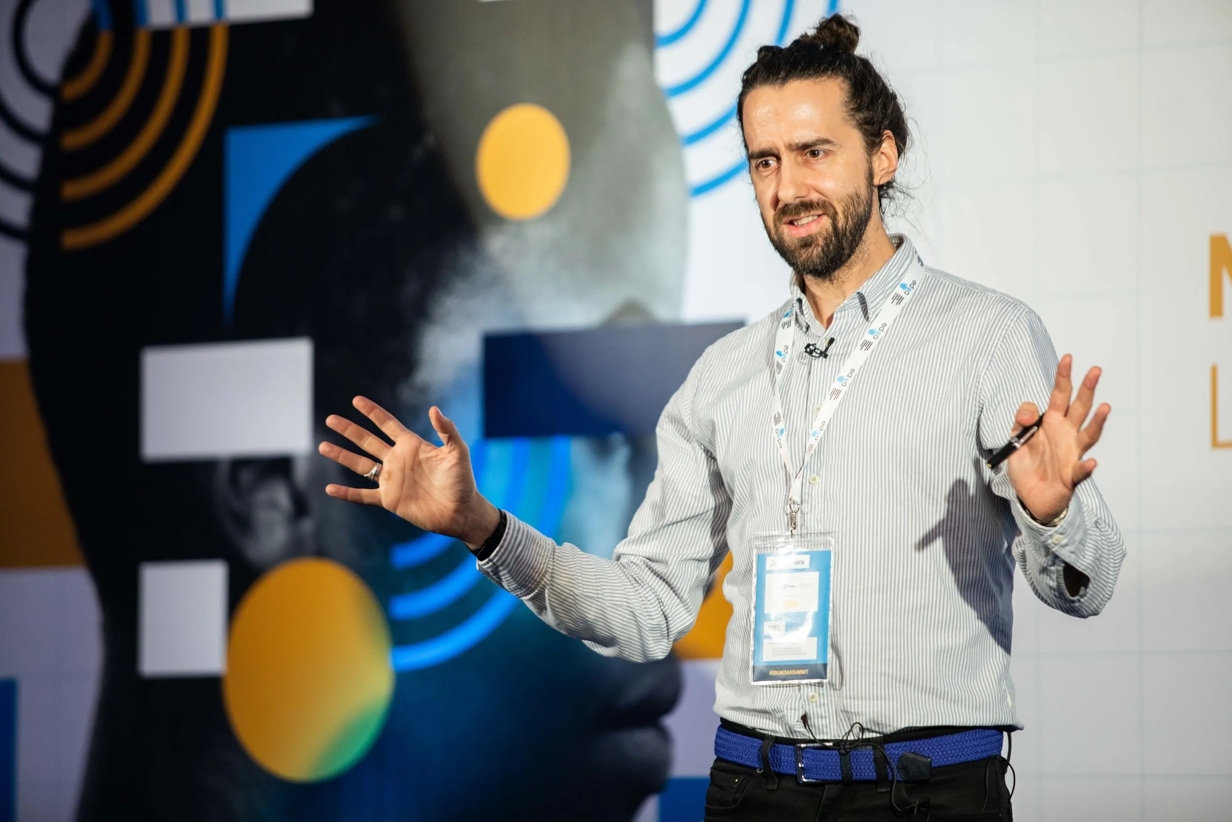 Keynote speaker on stage at a branded corporate conference, London event photography