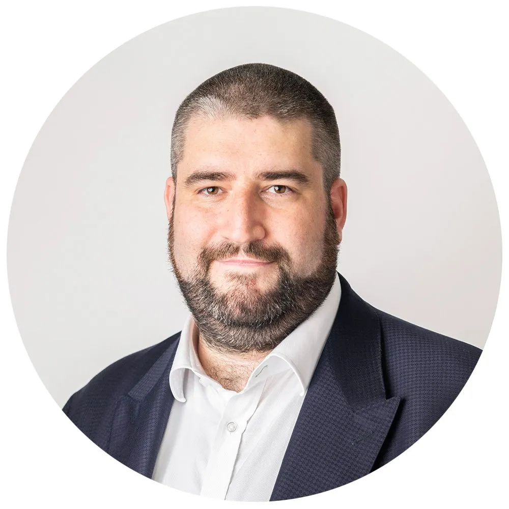 Corporate headshot of man with beard in navy blazer and white shirt, London