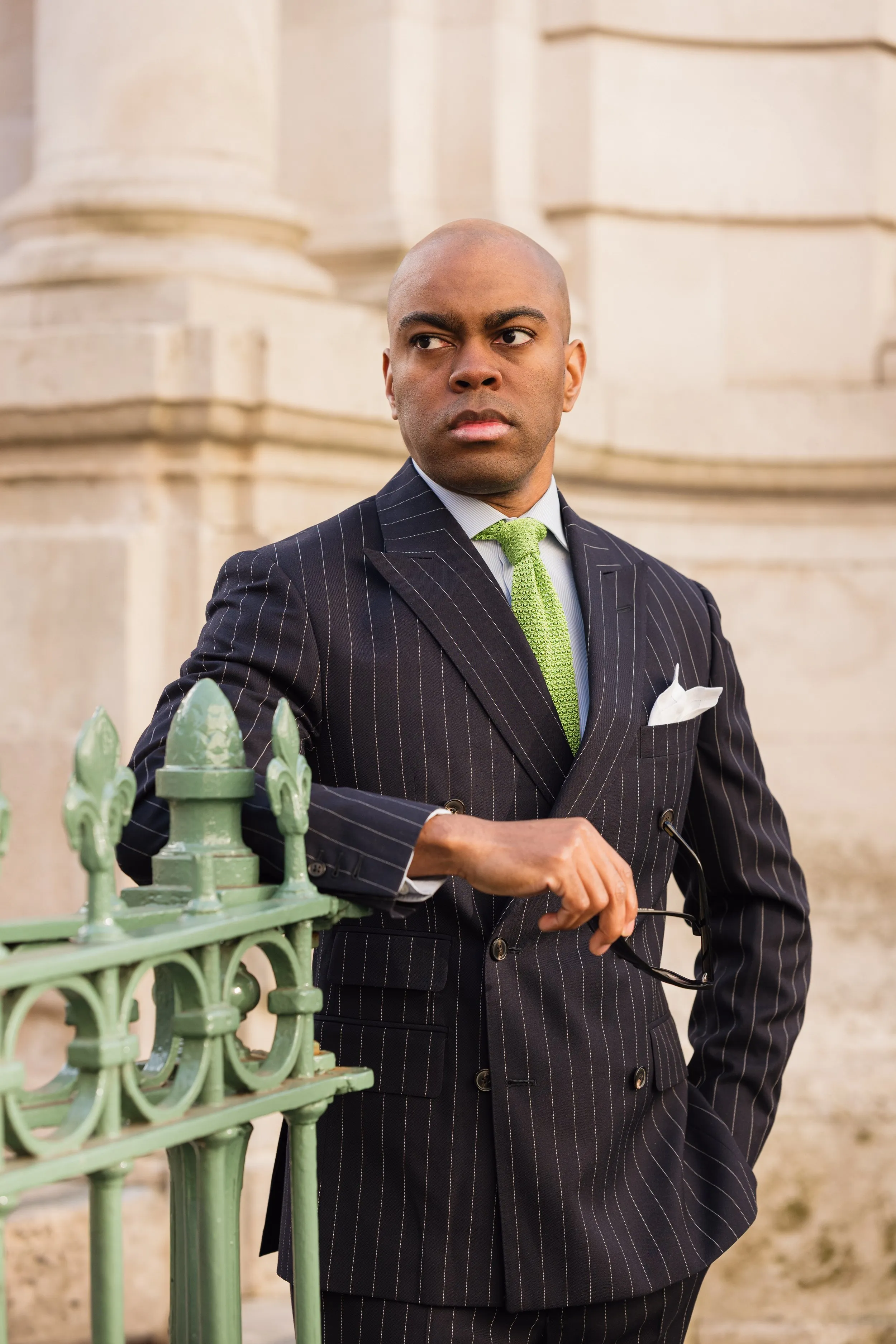 Outdoor corporate headshot of man in pinstripe suit with green tie, London