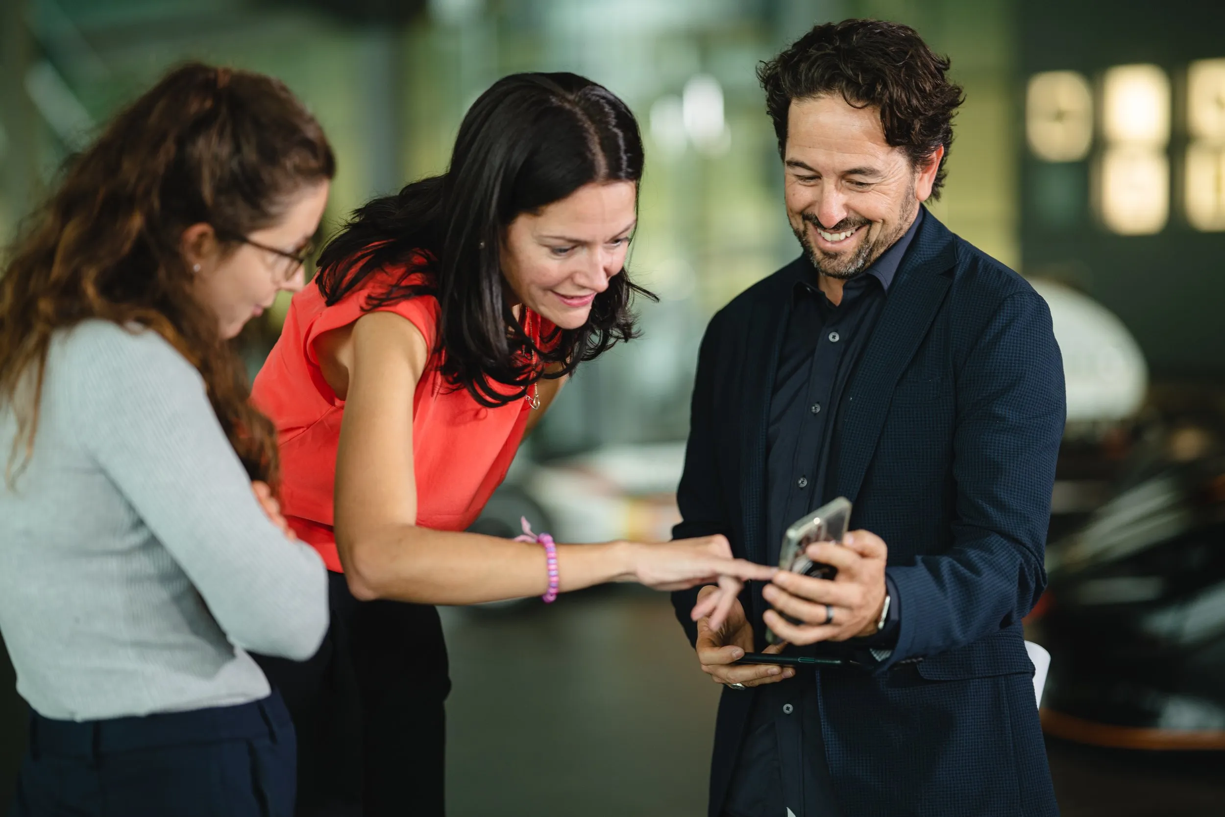 Colleagues looking at smartphone in a tech startup office, corporate lifestyle photography, London